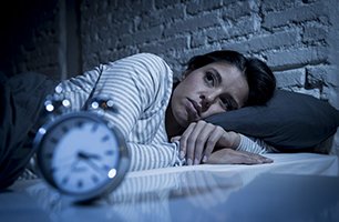 Woman laying in bed trying to sleep